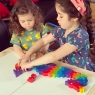 Two children playing with a wooden toy dragon jigsaw puzzle