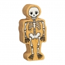 A chunky wooden white toy skeleton figure in profile with a natural wood edge