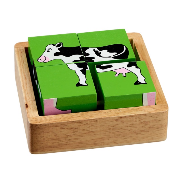Four piece farm block puzzle showing green side with cow design in a plain wooden tray