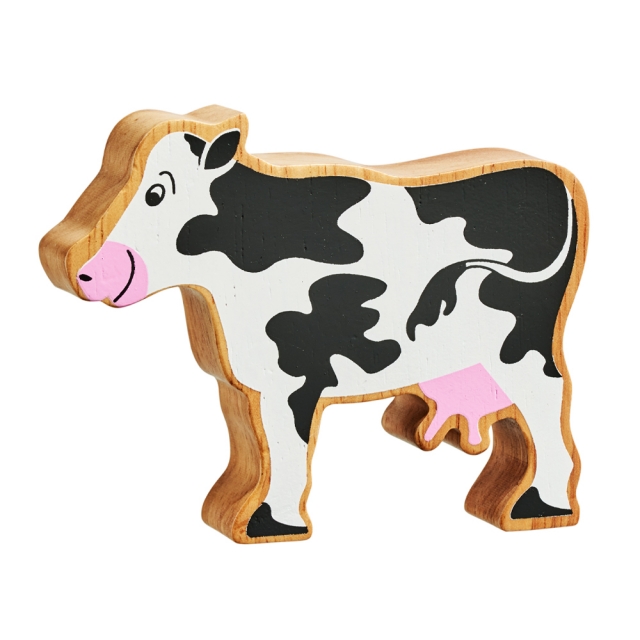 A chunky wooden black and white cow toy figure in profile with a natural wood edge