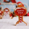A chunky wooden North Pole toy figure in profile with a natural wood edge