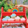 A child playing with assorted wooden toy weather pieces