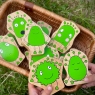 Child holding two green feeling folk characters with ten characters blurred in background