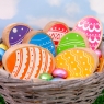 Wooden toy rainbow eggs in a wicker basket against a blue cloud background