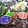 Wooden toy rainbow eggs with toy rabbit character on a log in a garden