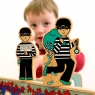 Child balancing wooden toy black and white burglar on top of toy world