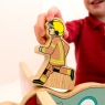 Child balancing wooden toy brown firefighter on top of toy world