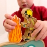 Child playing with firefighter and fire wooden toy figures
