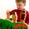 Child playing with Stone Age characters, balancing them on top of another toy