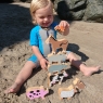 Child playing with selection of Lanka Kade animals including the black and white cow