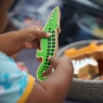 Child playing with a Lanka Kade green crocodile toy