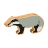 A wooden toy grey badger in profile with a natural wood grain edge