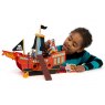 Child playing with red wooden Pirate ship with pirate in hand balancing the captain