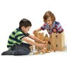 Two children playing with a natural wood castle and wooden knight figurines