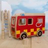 Red/ Yellow wooden fire engine playset in situ against cloud backdrop, peg people climbing ladder