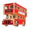 Child playing with red wooden double decker bus with roof removed and figurine characters in hand