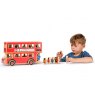 Child playing with red wooden double decker bus in profile and figurine characters in hand