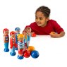 child throwing balls to knock down set of six wooden pirate skittles