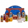 Wooden nativity scene and characters against a wicker backdrop with christmas decorations