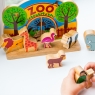 Child playing with zoo set with multicoloured animals and backdrop