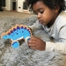 Child playing with blue stegosaurus push along