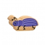 A chunky wooden purple beetle toy figure with a natural wood edge