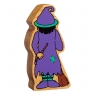 Reverse view of chunky wooden purple and green toy witch figure in profile with a natural wood edge