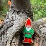 A chunky wooden green and red toy gnome figure