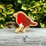 A chunky wooden robin toy figure in profile with a natural wood edge