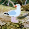A chunky wooden seagull toy figure resting on a branch
